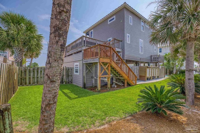 rear view of property with a deck and a yard