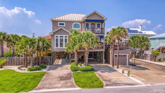 view of front facade with a front lawn, a balcony, a carport, and a garage