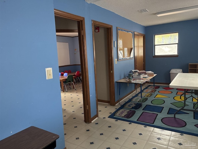 hall featuring a textured ceiling