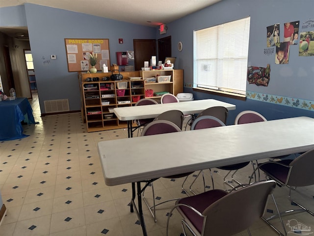 dining area with lofted ceiling and light tile patterned floors