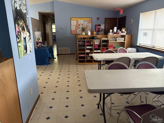 dining area with lofted ceiling and light tile patterned floors