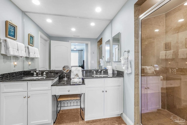 full bathroom featuring double vanity, a stall shower, and a sink