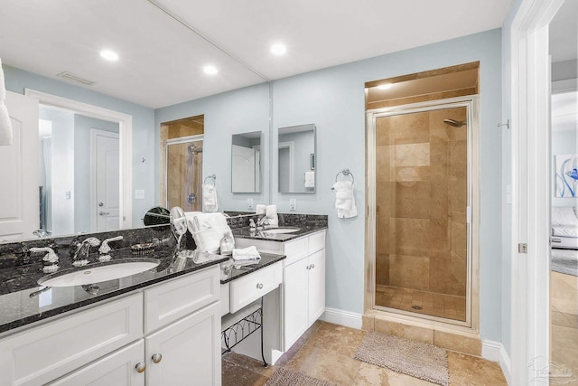 bathroom featuring a sink, visible vents, baseboards, double vanity, and a stall shower