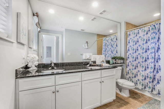 bathroom with visible vents, a sink, toilet, and double vanity