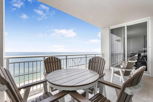 balcony featuring a view of the beach and a water view