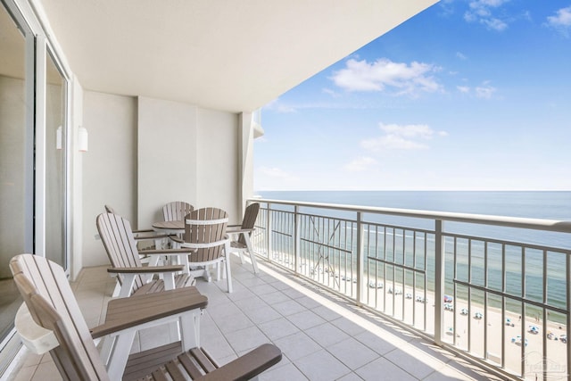 balcony featuring a water view and a view of the beach