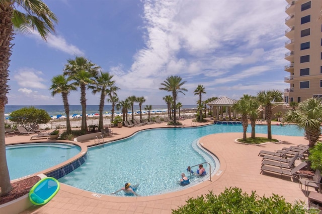 community pool featuring a water view, a patio area, and a gazebo