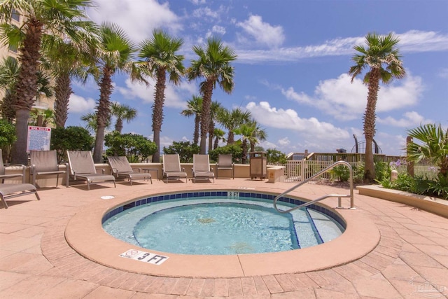 view of swimming pool with fence, a community hot tub, and a patio