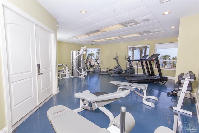 gym featuring baseboards, visible vents, a drop ceiling, and recessed lighting