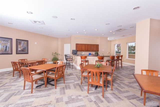 dining room featuring light carpet, visible vents, and baseboards