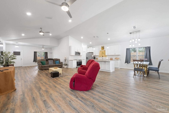 living area featuring vaulted ceiling, recessed lighting, wood finished floors, and visible vents