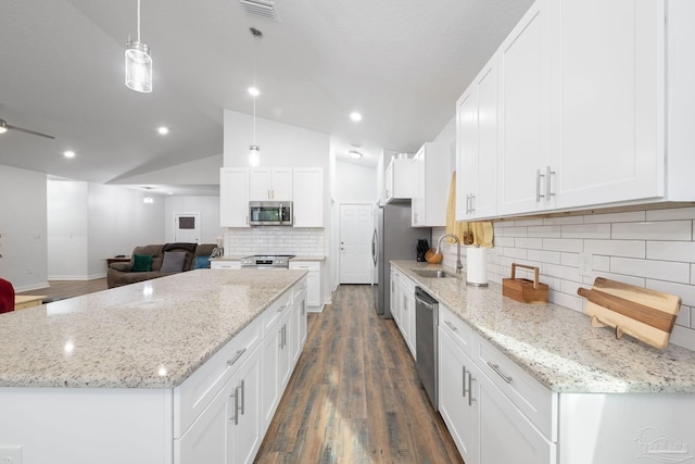 kitchen with a kitchen island, lofted ceiling, appliances with stainless steel finishes, dark wood-style floors, and white cabinetry