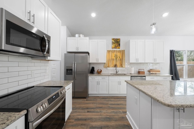 kitchen with a sink, appliances with stainless steel finishes, white cabinets, and dark wood-style flooring