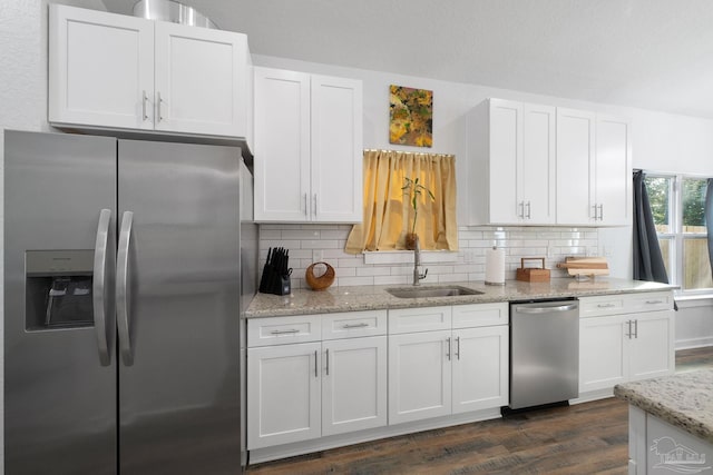 kitchen with decorative backsplash, appliances with stainless steel finishes, white cabinetry, and a sink