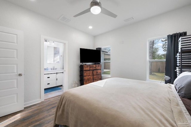 bedroom with visible vents, recessed lighting, a sink, dark wood-type flooring, and connected bathroom