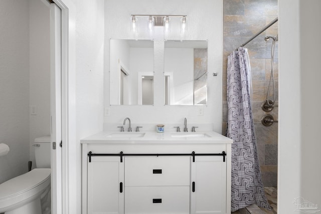 full bath featuring toilet, tiled shower, and a sink