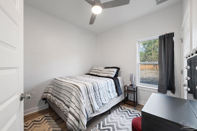 bedroom featuring visible vents, baseboards, and wood finished floors