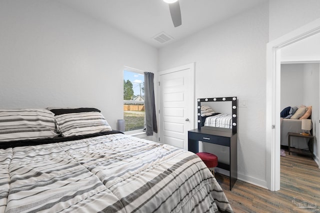 bedroom featuring a ceiling fan, wood finished floors, visible vents, and baseboards