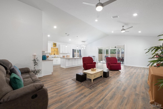 living area featuring a ceiling fan, wood finished floors, visible vents, baseboards, and lofted ceiling