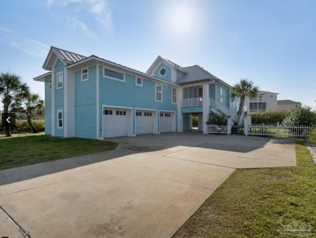 view of front of house featuring a garage, a front lawn, and a balcony