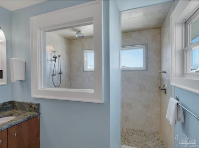 bathroom with vanity and tiled shower