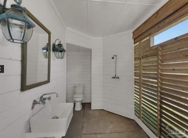 bathroom with concrete floors and toilet