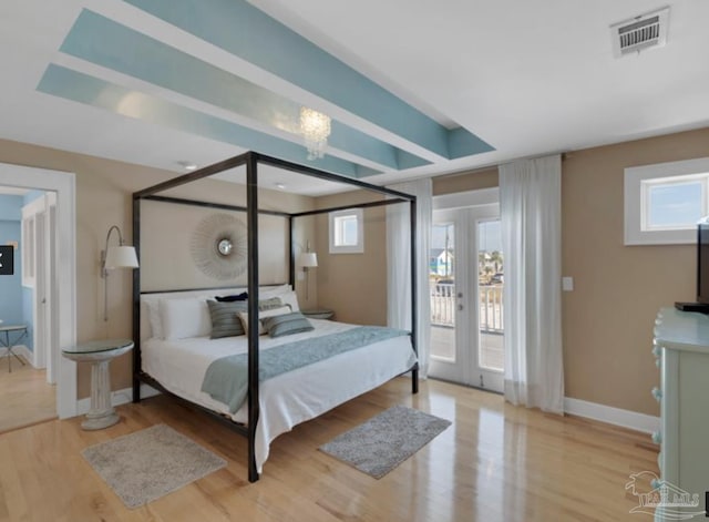 bedroom with access to exterior, light wood-type flooring, and french doors