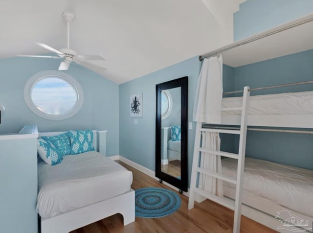 bedroom with hardwood / wood-style flooring, vaulted ceiling, and ceiling fan