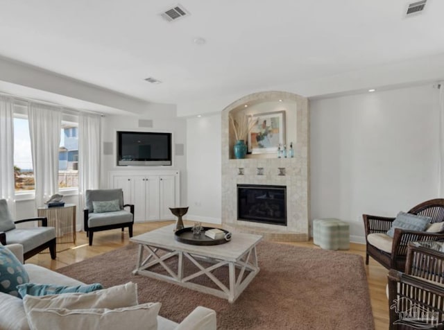 living room featuring a large fireplace and light hardwood / wood-style floors