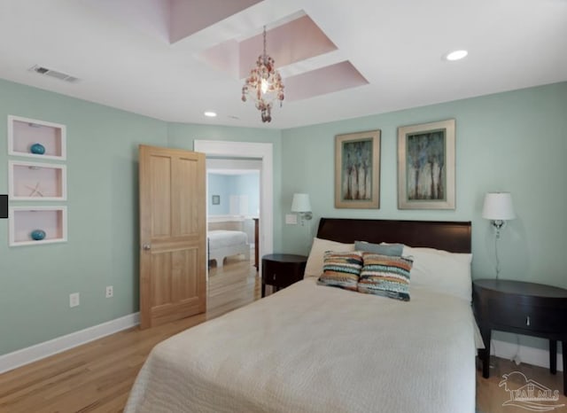 bedroom with a chandelier and light hardwood / wood-style flooring