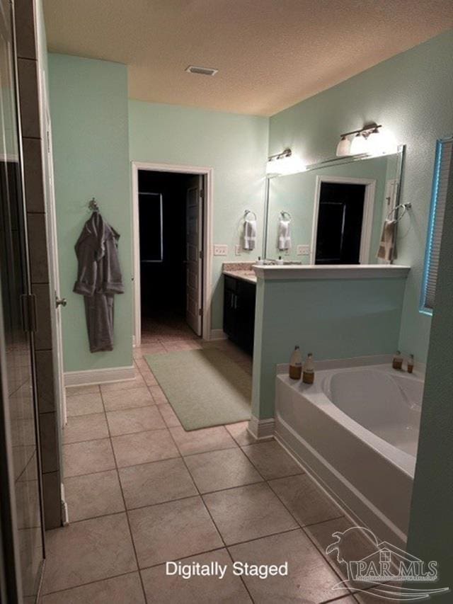 bathroom with tile patterned flooring, vanity, and a bathtub