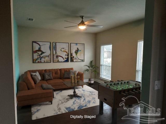 living room featuring dark wood-type flooring and ceiling fan