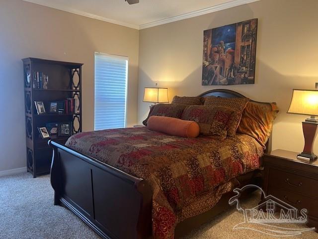 carpeted bedroom with ornamental molding