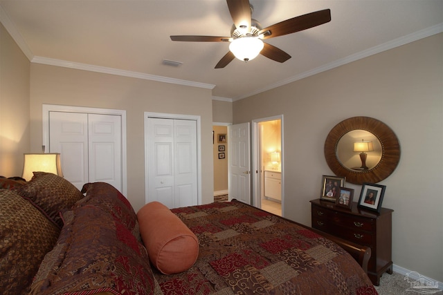 carpeted bedroom featuring ornamental molding, ensuite bath, ceiling fan, and multiple closets