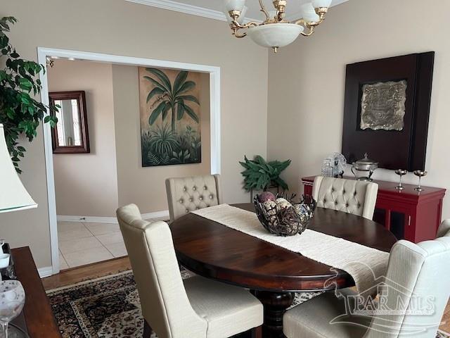 dining space featuring an inviting chandelier, hardwood / wood-style floors, and crown molding