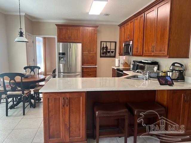 kitchen featuring crown molding, stainless steel appliances, decorative light fixtures, light tile patterned floors, and kitchen peninsula