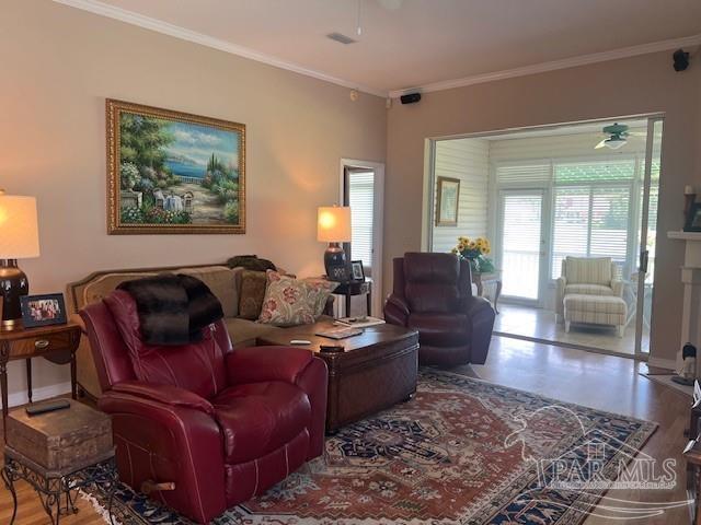 living room featuring ceiling fan, hardwood / wood-style flooring, and ornamental molding