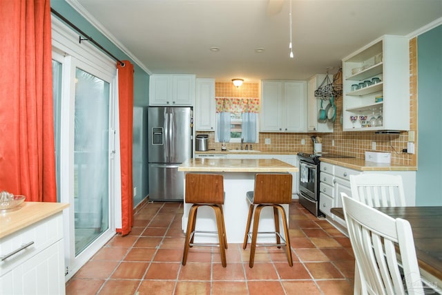 kitchen featuring tasteful backsplash, a center island, white cabinets, and appliances with stainless steel finishes