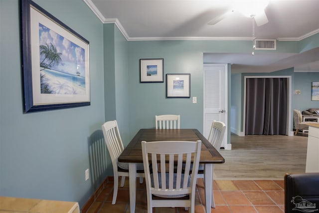 dining space with ceiling fan, crown molding, and light wood-type flooring