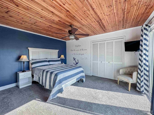 bedroom featuring ceiling fan, a closet, carpet floors, and wood ceiling