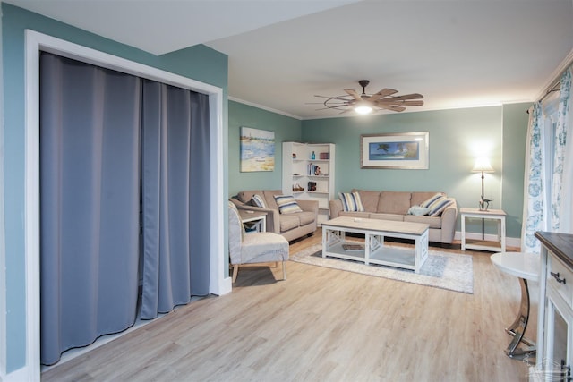 living room with ceiling fan, ornamental molding, and light wood-type flooring