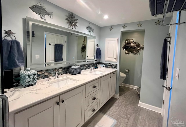 bathroom with vanity, toilet, wood-type flooring, and backsplash