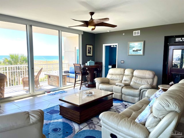 living room with a water view, a healthy amount of sunlight, and ceiling fan