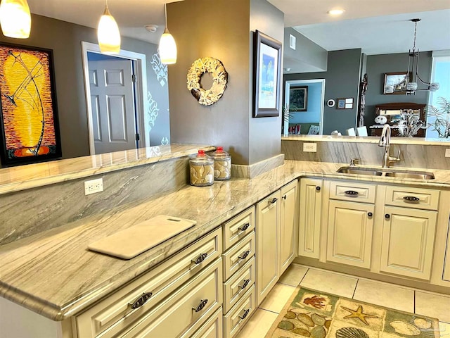 kitchen with sink, kitchen peninsula, decorative light fixtures, and light tile patterned floors