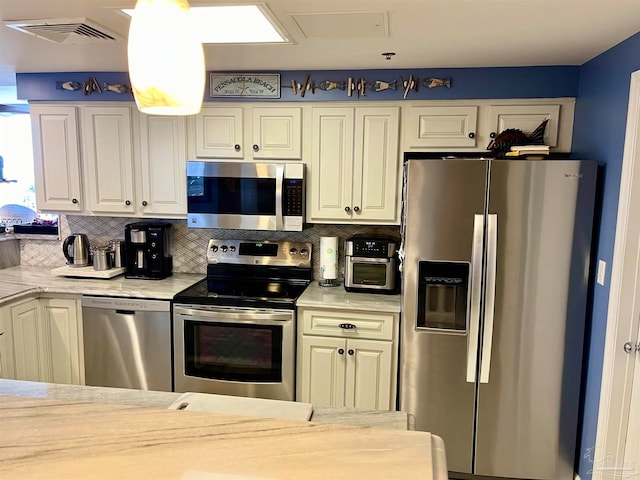 kitchen with light stone countertops, stainless steel appliances, and backsplash