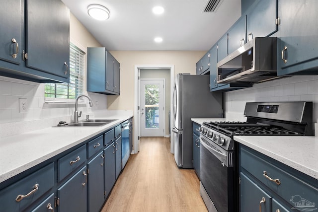 1010 W Lloyd St, Pensacola, FL 32501 - kitchen featuring stainless steel appliances, a sink, blue cabinetry, light wood-style floors, and recessed lighting