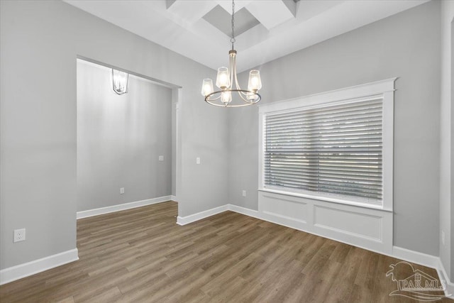 unfurnished room featuring hardwood / wood-style flooring and a notable chandelier