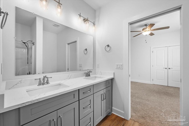 bathroom featuring ceiling fan, walk in shower, and vanity