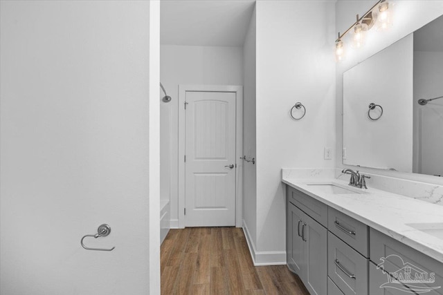 bathroom featuring a bath, vanity, and wood-type flooring