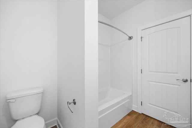 bathroom featuring  shower combination, toilet, and wood-type flooring